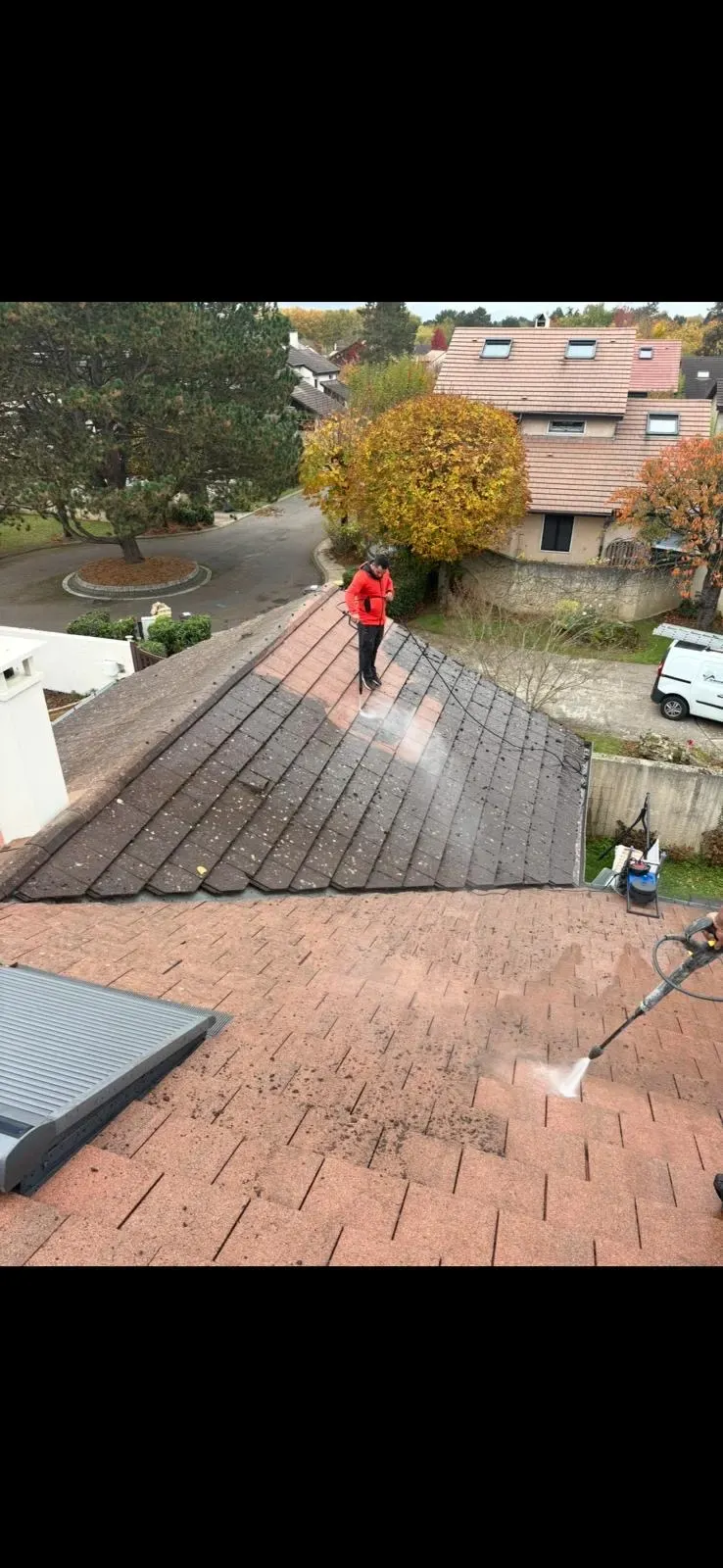 Démoussage d'une toiture en tuiles par SDR Habitat 44, moitié nettoyée moitié couverte de mousse
