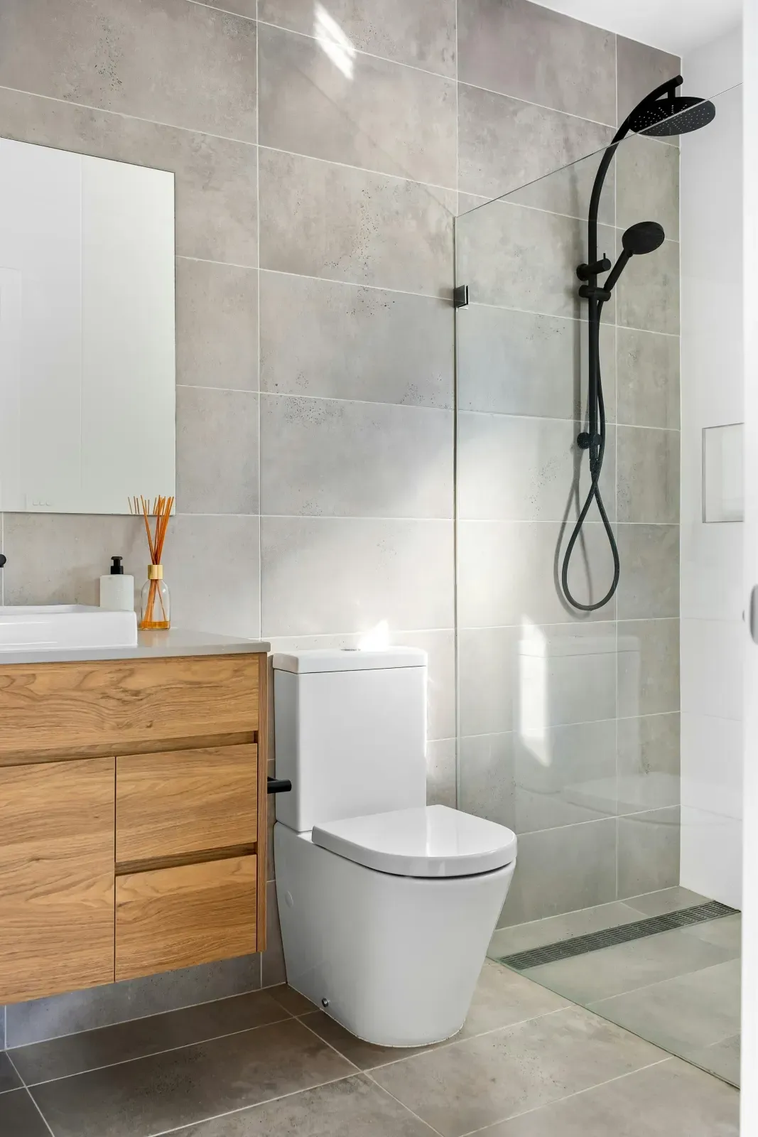 Salle de bain avec carrelage grand format et meuble bois