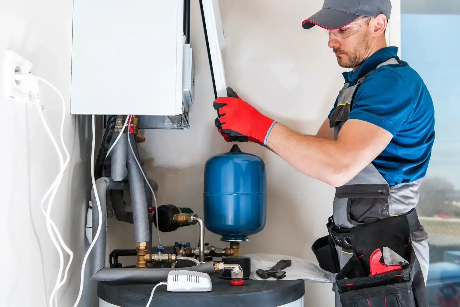 Technicien sur une chaudière et son vase d'expansion